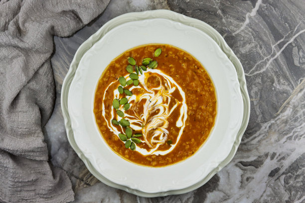 扁豆汤。在灰色大理石的背景上，自制的西红柿和扁豆汤和蔬菜。图片下载