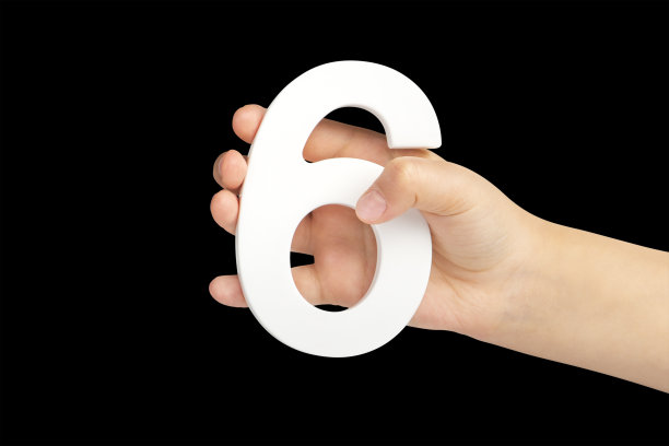在黑色背景上，6号手拿着。一个孩子拿着6号，背景是黑色的。插入:插入到一个项目或设计中图片下载