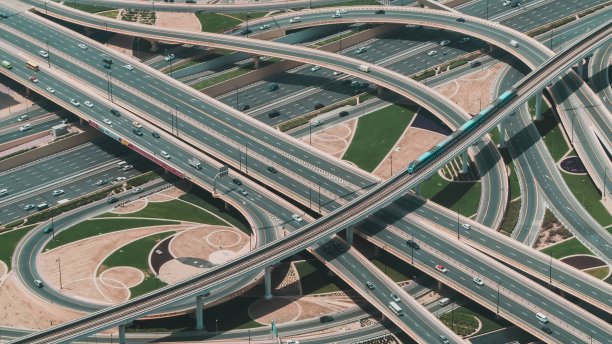 多条道路交汇的大型公路高角度拍摄，火车从中穿过图片下载