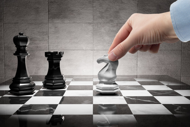 在国际象棋中，手移动马对抗国王和炮塔。图片下载