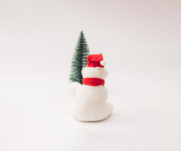 北极熊坐在新年的圣诞树上看。图片下载