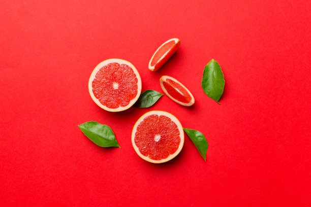 新鲜水果柚子与多汁的柚子切片彩色背景。前视图。副本的空间。创意夏日概念。一半的柑橘在最小的平坦铺设与复制空间图片下载