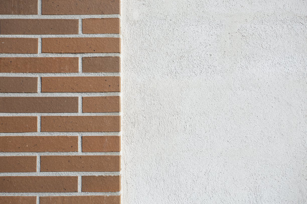 部分长方形的棕色砖背景和部分光滑的白色纹理墙。复制空间。图片下载