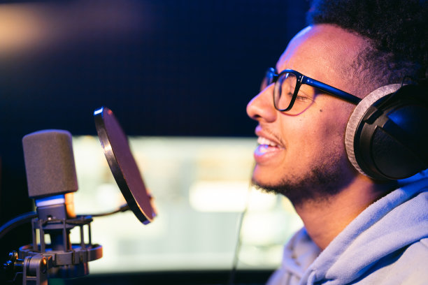 年轻男歌手在录音棚霓虹灯下表演图片下载