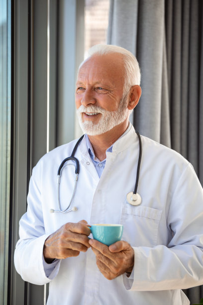 高级成熟的医疗保健专业人员，医生的画像，拿着听诊器拿着蓝色的咖啡，图片下载