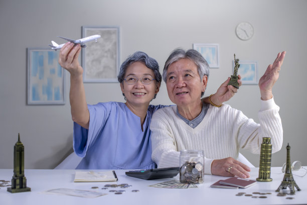 一对快乐的亚洲老夫妇计划攒钱环游世界。图片下载