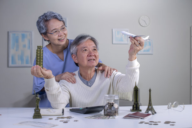 一对快乐的亚洲老夫妇计划攒钱环游世界。图片下载