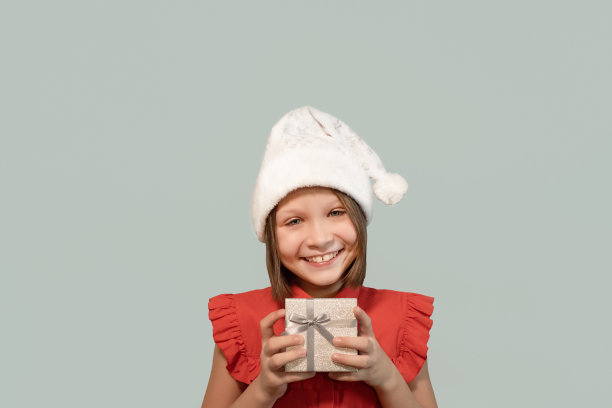 一个手里拿着礼品盒微笑的女孩。节日和活动。圣诞节图片下载