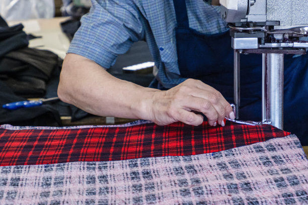 服装工人使用电动机器切割布料。纺织工业图片下载