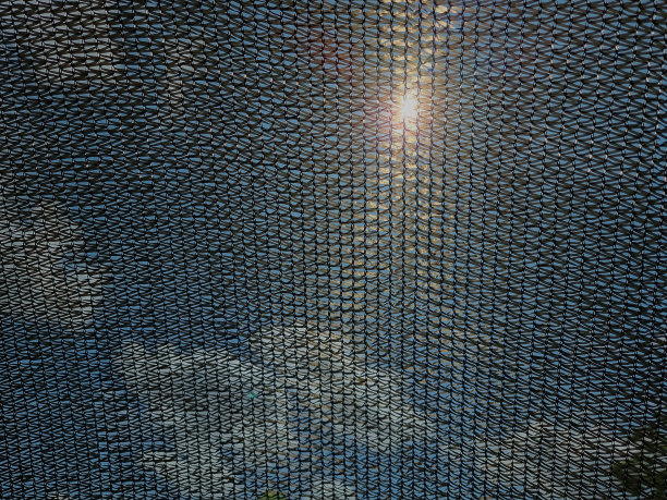 黑色遮阳网。白云和太阳被网挡住了，看不清楚。图片下载