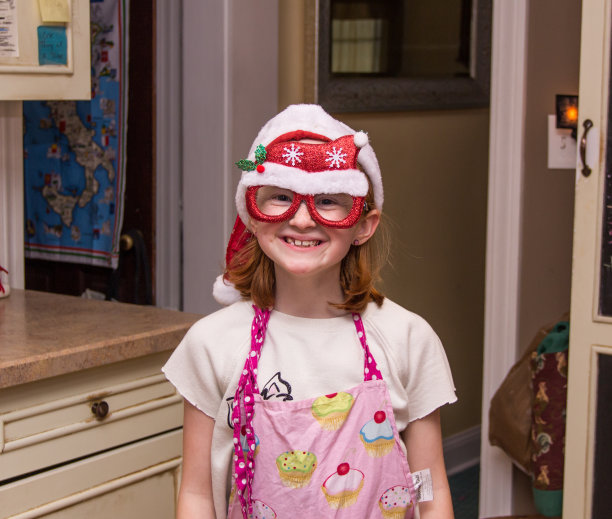 浅聚焦镜头一个可爱的女孩戴着圣诞帽和眼镜图片下载
