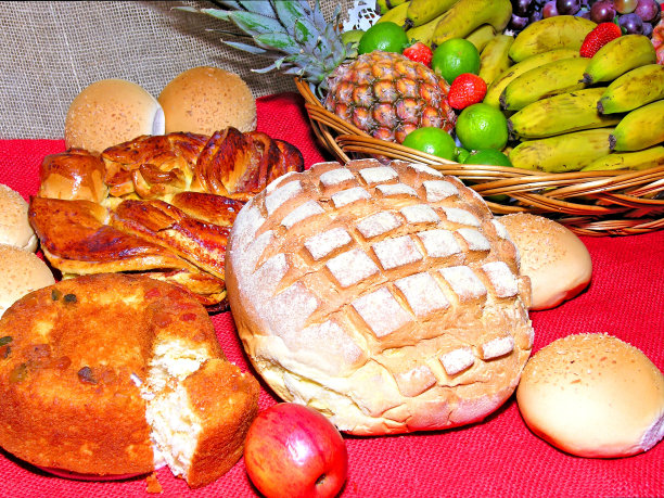 什锦面包，蛋糕放在红黄麻装饰的桌子上。柳条篮子里有香蕉，菠萝，莱姆图片下载