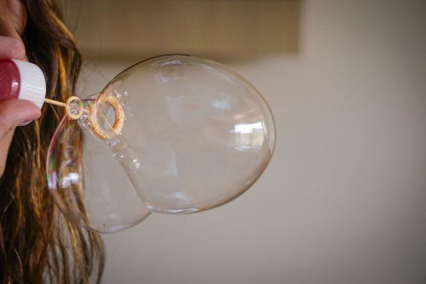 一个女人用肥皂水吹气制造气球的特写图片下载