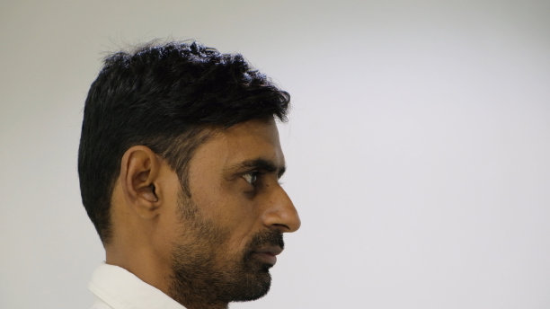 一个留着胡茬的南亚男性的侧视图，直视前方，远离相机图片下载