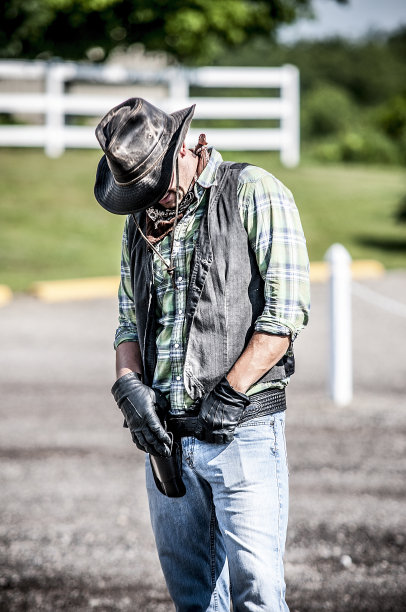 垂直拍摄的男性穿着牛仔如果他的手在腰带和向下看图片下载