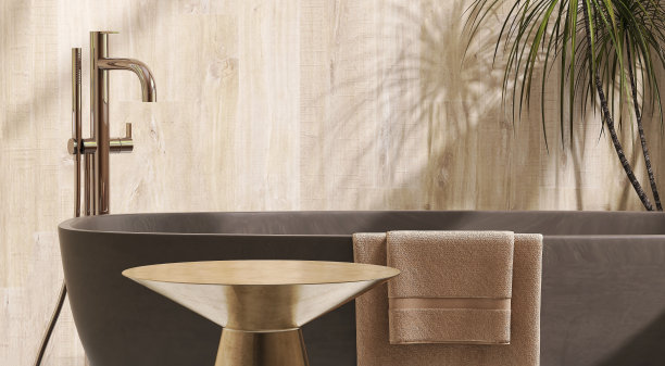 金色黄铜金属边桌在豪华设计浴室的棕色浴缸和热带树斑驳的阳光从窗户和米色水泥墙上的叶影图片下载