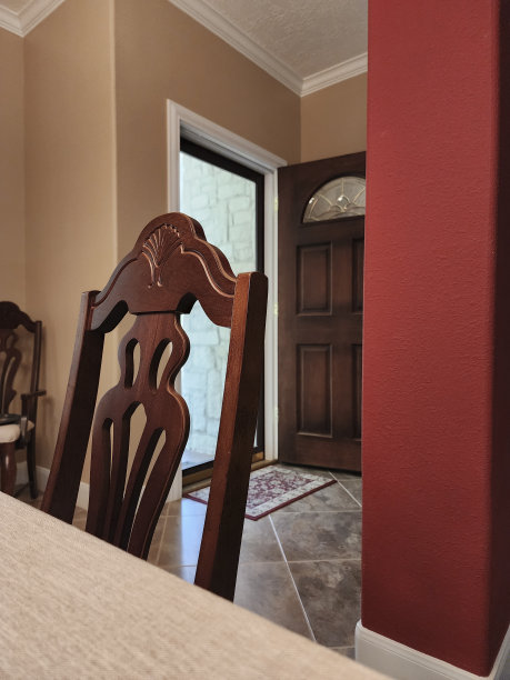 日常用品-餐桌上的餐椅与打开的前门为背景。图片下载