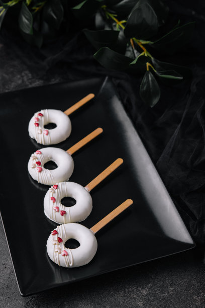 棒棒糖慕斯放在黑色盘子里图片下载