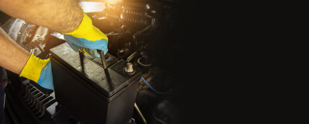 汽车修理工正在更换汽车发动舱内的电池图片下载