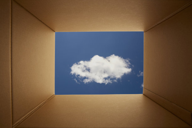 透过纸板箱向蓝色的天空背景看。图片下载