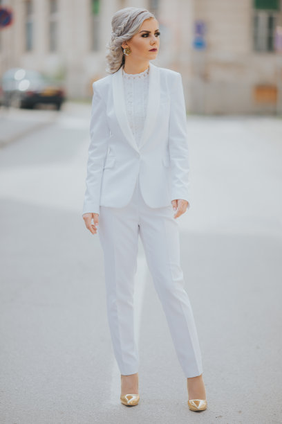 优雅时尚的白人女性在漂亮的白色西装和裤子摆姿势为时尚照片图片下载
