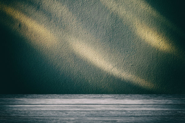 木桌中央有聚光灯，旧的垃圾混凝土墙，暗色调和纹理，适合万圣节的概念。图片下载