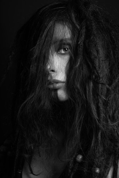 工作室女性肖像化妆和杂乱的脏辫头发覆盖她的脸图片下载