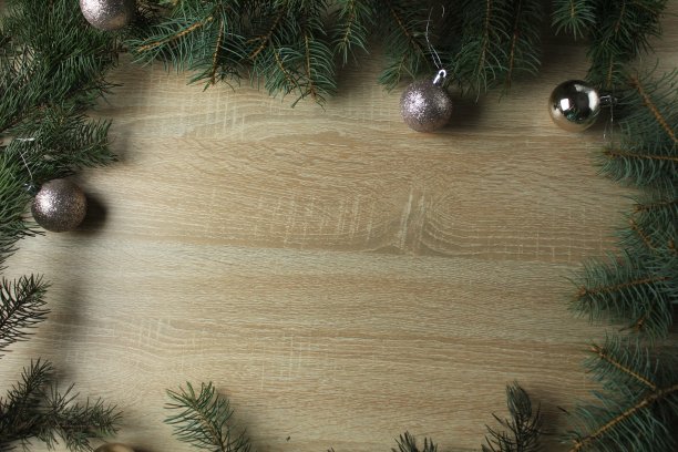 新年的圣诞背景。圣诞云杉树枝与银球在木制背景与空间copyspace文本图片下载