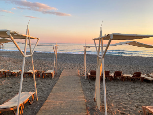 阳光躺椅和遮阳伞在海边的海滩上度假，在一个温暖的东部热带国家的旅游胜地图片下载