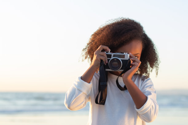 感兴趣的女孩的肖像与老式相机图片下载