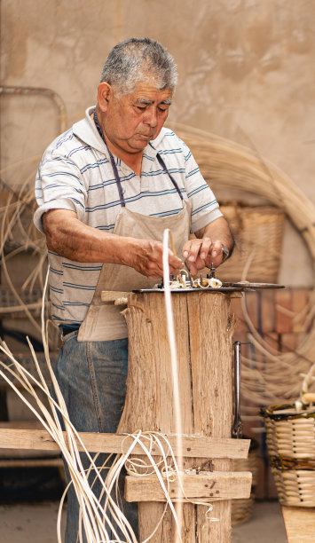 成熟的拉丁美洲男子在柳条作坊规划柳条。拉丁文化和传统观念图片下载