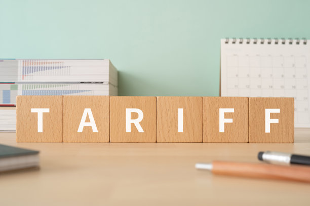 带有“TARIFF”文字概念的木块、笔、笔记本和书籍图片下载