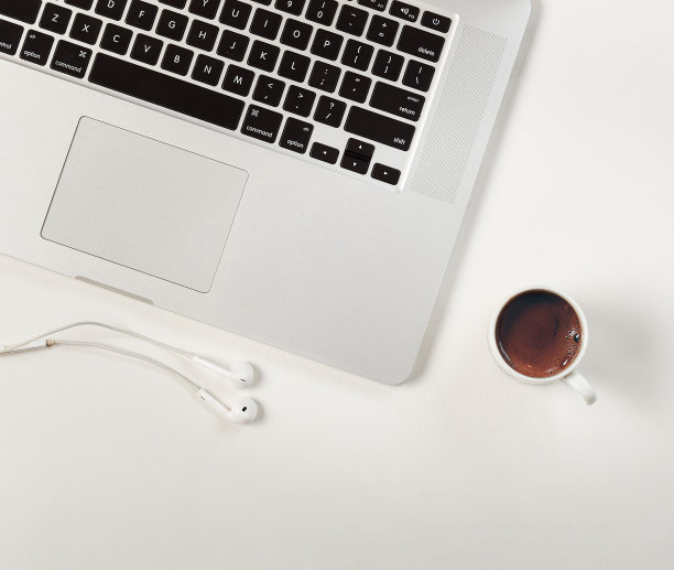 俯视一杯咖啡旁边的笔记本电脑与耳机图片下载