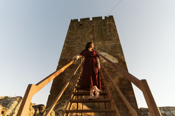 一名年轻的白人女子站在葡萄牙朗洛瓦城堡的木楼梯上的低角度镜头图片下载