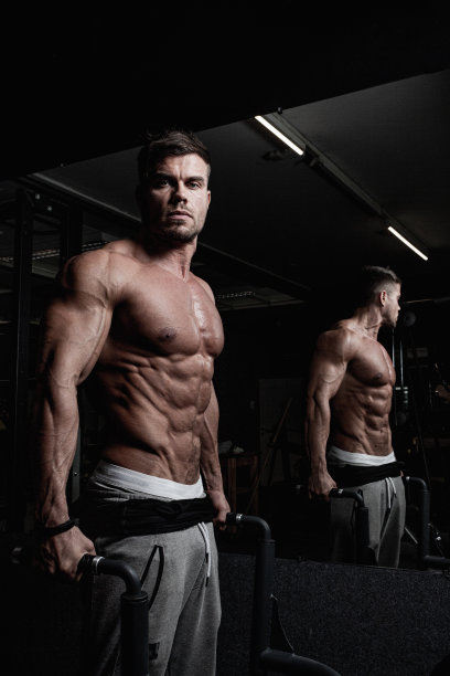 一个英俊的健壮的奥地利男子在晚上一个黑暗的健身房辛苦锻炼图片下载