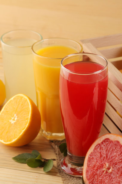 柑橘类果汁。橙汁，柠檬和西柚汁与新鲜水果在一个盒子上天然的木制背景图片下载