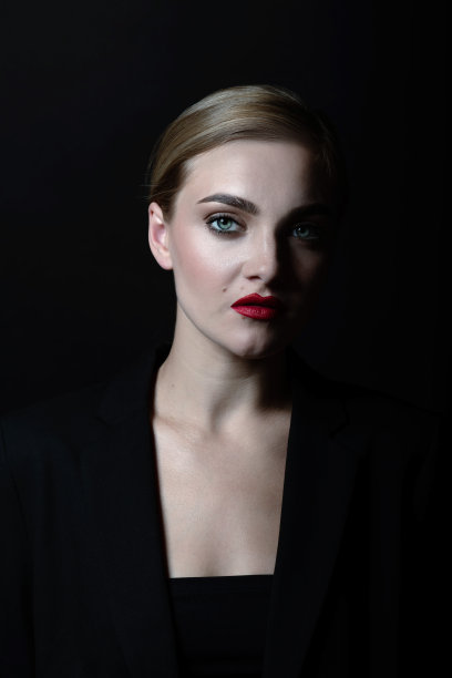 美丽的女人与经典的发型和黑色套装特写工作室肖像图片下载