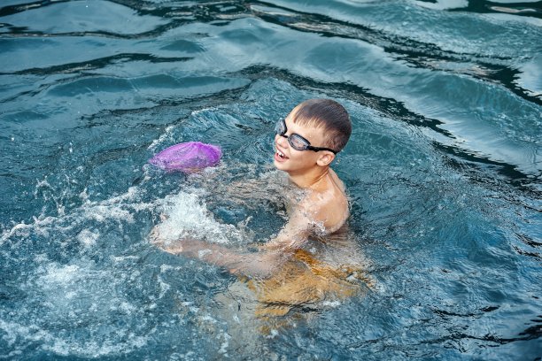 男孩喜欢在海里游泳，微笑着特写镜头图片下载
