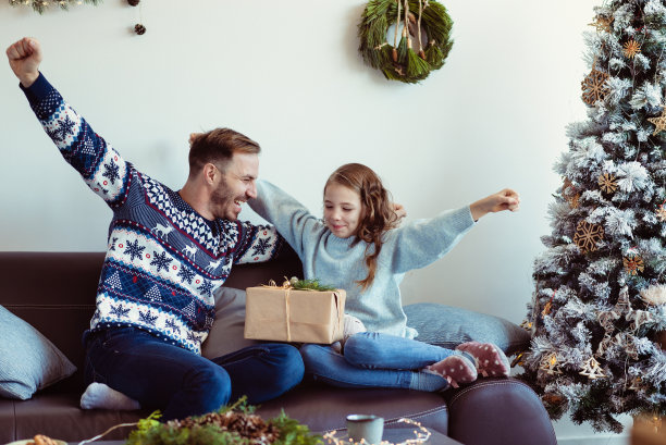 慈爱的父亲给他的孩子一份圣诞礼物，欢呼和欢笑图片下载