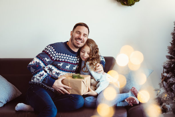 在圣诞节的早晨，慈爱的父亲和女儿拥抱在一起图片下载