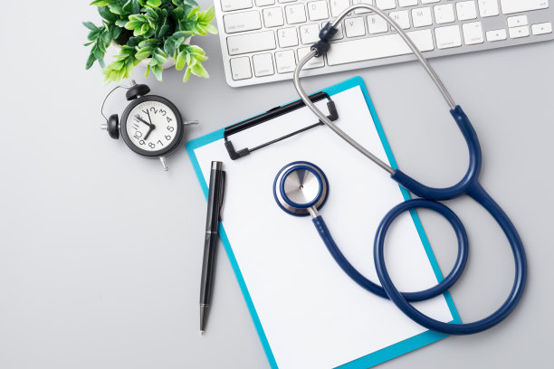 医生办公桌，听诊器，电脑键盘和笔，俯视图图片下载