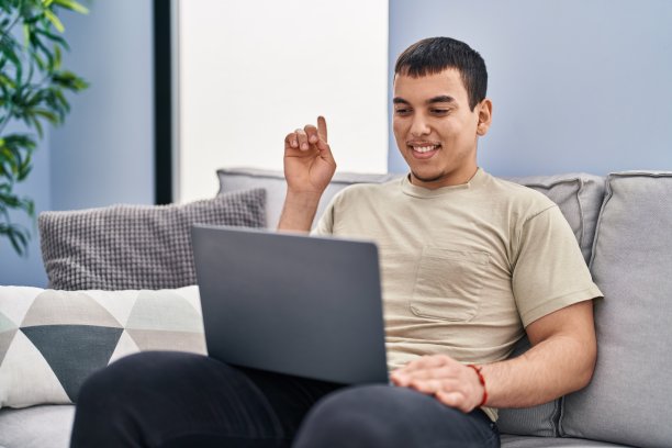 年轻的阿拉伯人在家里用笔记本电脑微笑快乐地指着一边用手和手指图片下载