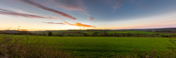 壮观多彩的日出在林堡南部绵延起伏的丘陵上，蜿蜒的道路和农田图片下载