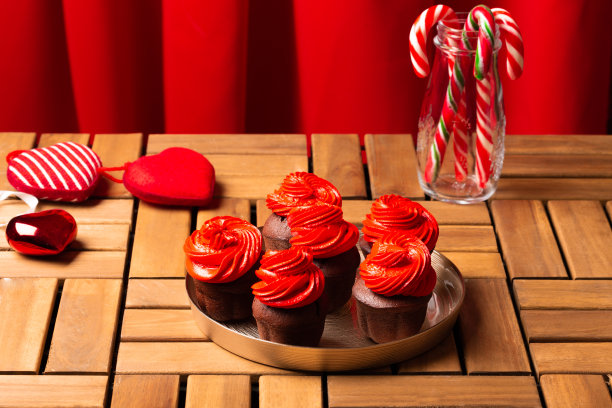 木桌上放着红色奶油的圣诞纸杯蛋糕图片下载
