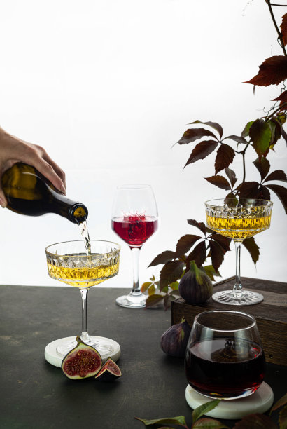 用手倒酒。三杯与白，玫瑰和红酒在黑暗的背景与复制空间图片下载