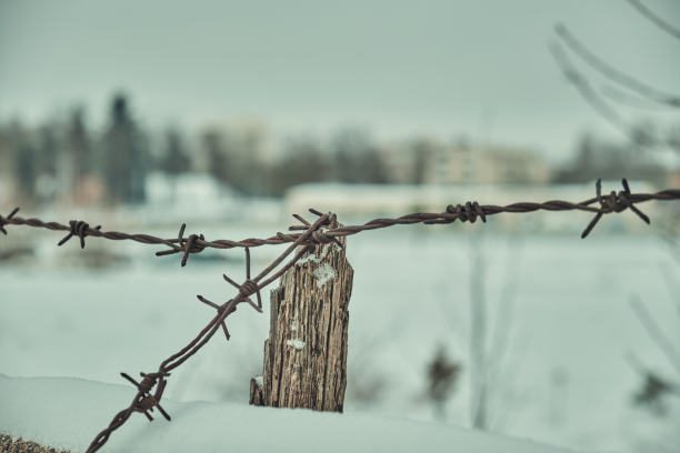 旧铁丝网上的混凝土栅栏在冬天的雪大特写选择性聚焦图片下载