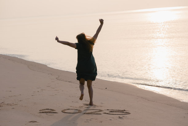 2023新年快乐，年轻健康女子在日出的海滩上奔跑跳跃，健康保健，健康保险，健康生活理念，复制空间为旗帜。图片下载