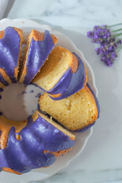 垂直特写的海绵柠檬蛋糕薰衣草在一个白色盘子上的桌子图片下载