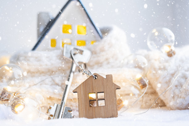 钥匙的房子与钥匙链上一个舒适的家与圣诞装饰。新年、圣诞节的礼物。建筑，设计，工程，搬迁到新房子，抵押，租赁和购买房地产图片下载