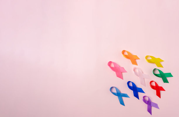 粉红色背景上的彩色丝带，癌症意识，世界癌症日，国家癌症幸存者日，世界自闭症，支持人们生活和疾病，前列腺意识概念。图片下载